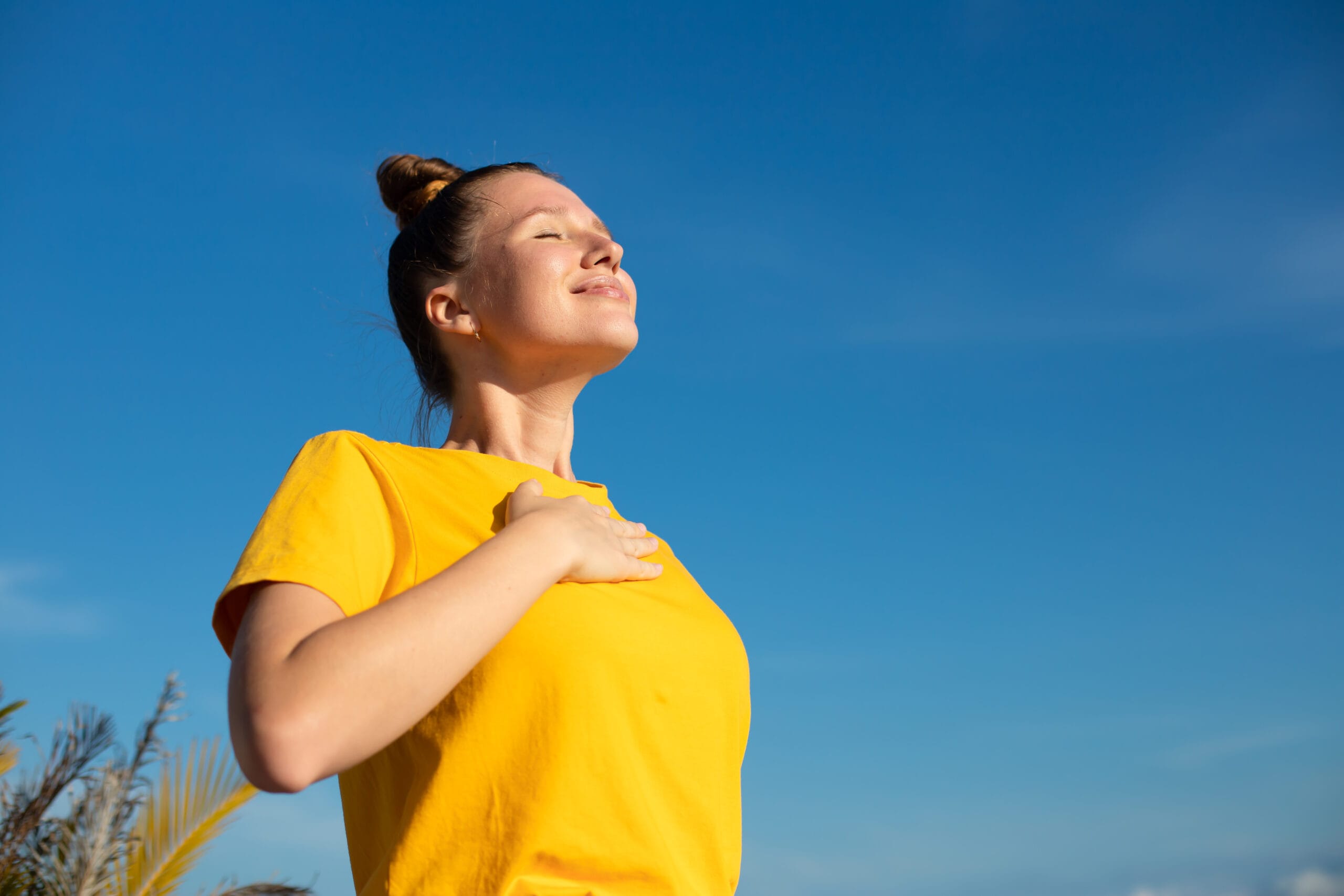Happy joyful positive girl, young beautiful feeling carefree woman is enjoying vacation at summer sunny day, sunbathing, tanning and smiling. Happiness, freedom concept on sky natural background